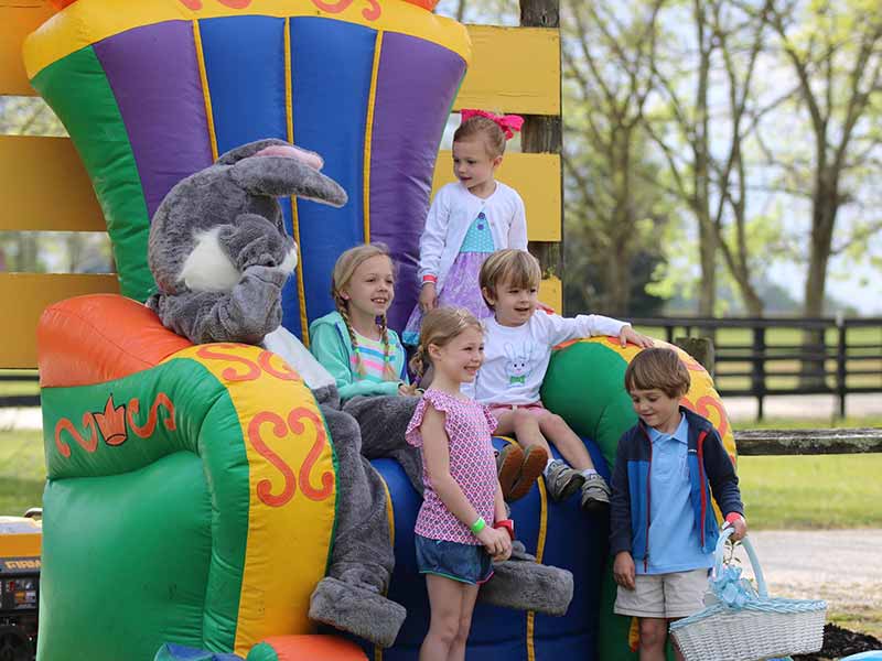 Children sitting with Easter bunny on large inflatable chair